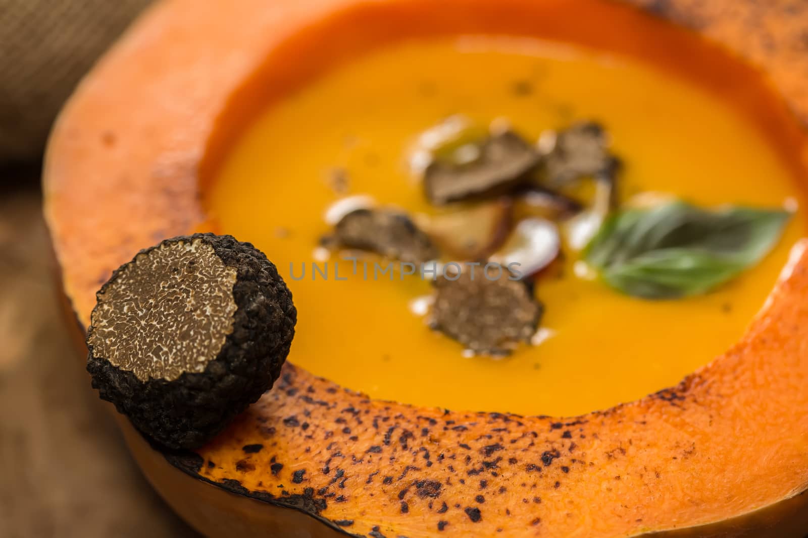 Cream of pumpkin soup with pumpkin seeds and and garlic croutons  in hollowed-out pumpkin. Shallow dof.