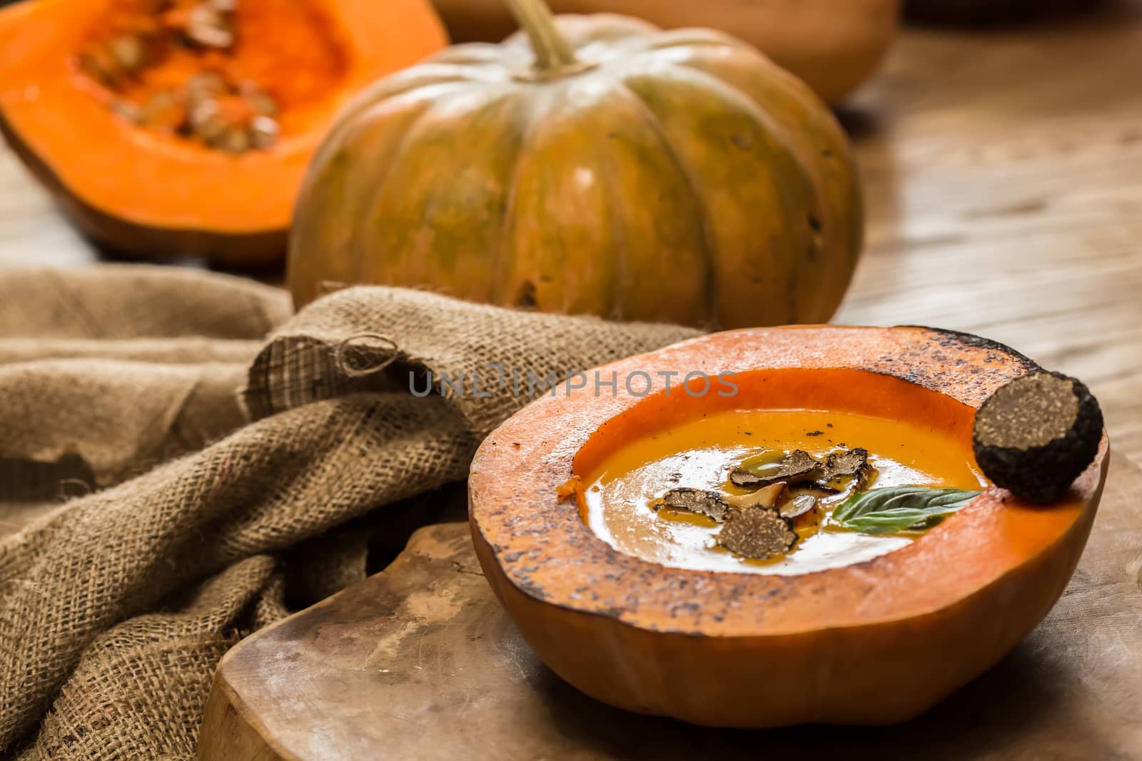 Cream of pumpkin soup with pumpkin seeds and and garlic croutons  in hollowed-out pumpkin. Shallow dof.