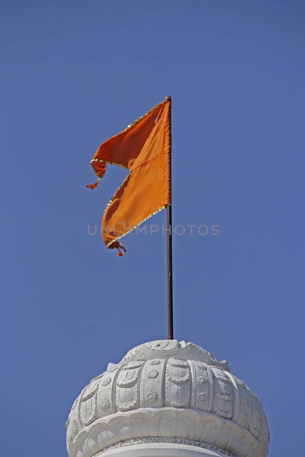 Orange Hindu temple flag in the breeze at Shrinath Mhaskoba Temple, Kodit, Sasvad, Maharashtra, India.