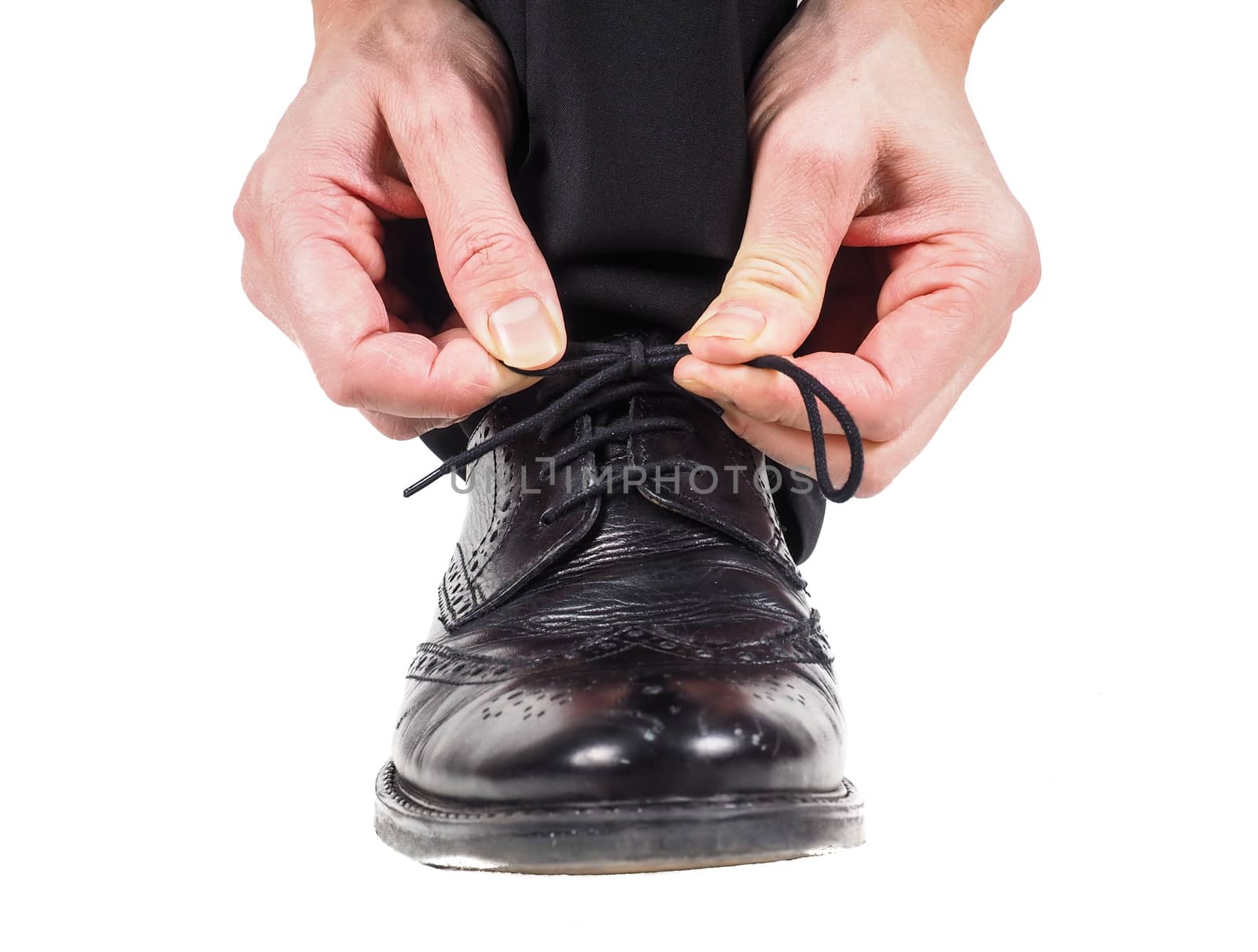 Male hands tying shoelaces on black leather shoes by Arvebettum