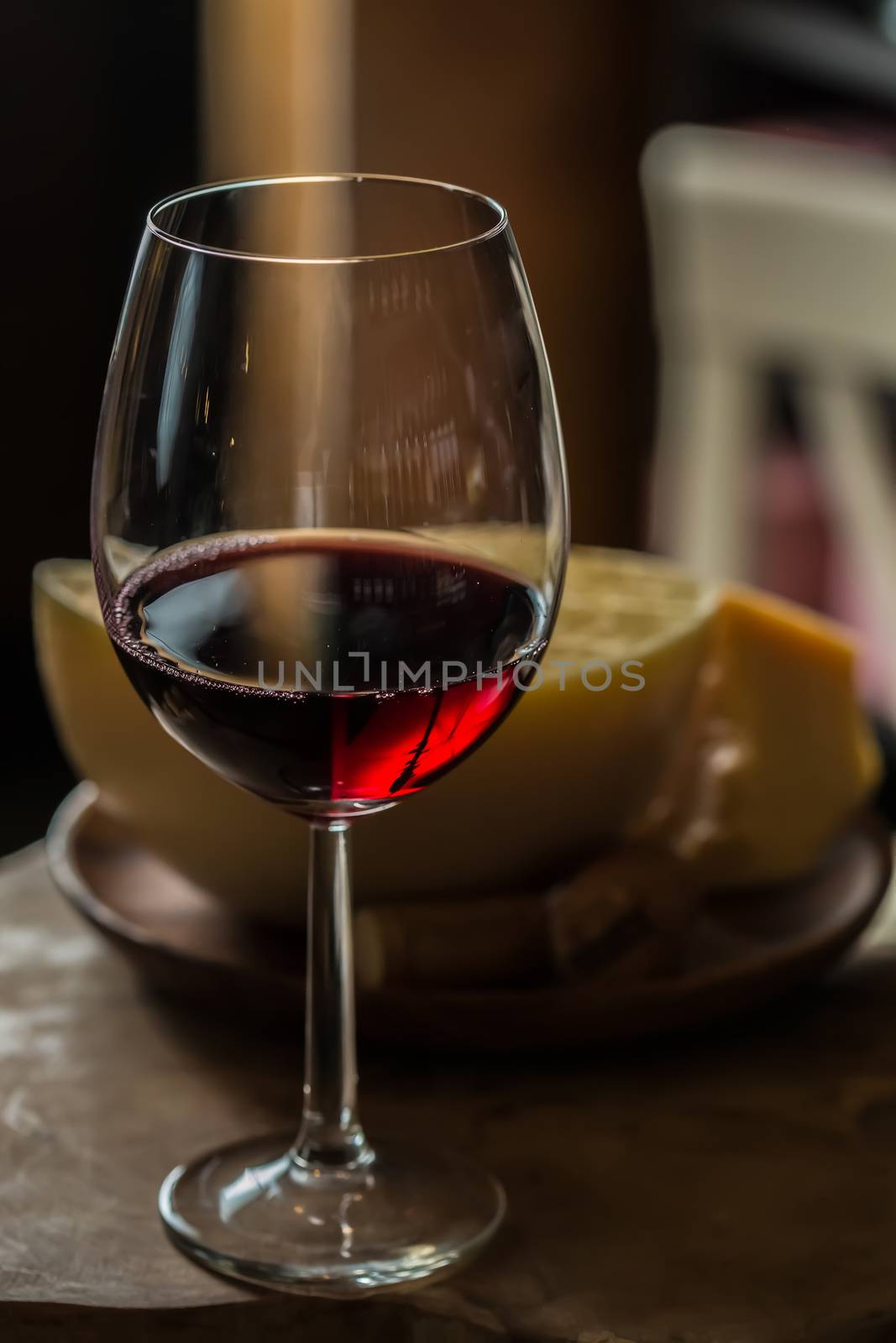 Red wine in wine glass with cheese. Selective Focus. Focus on the front of the rim of the wine glass