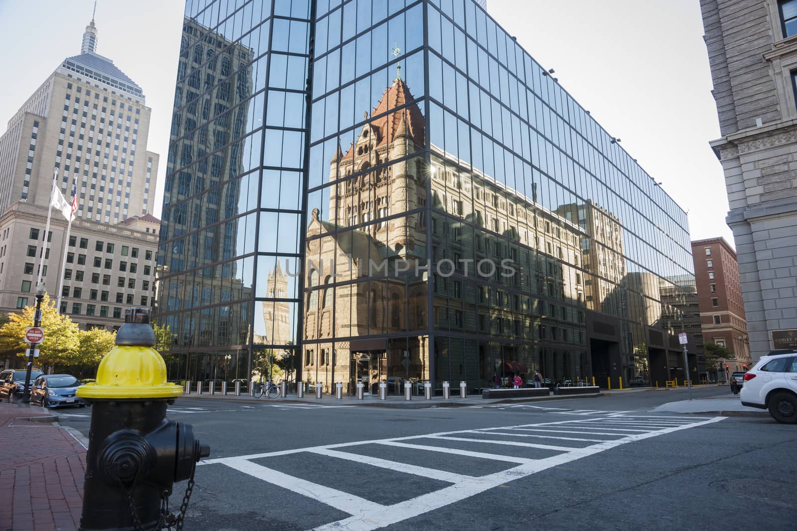 Urban mirror image, Victorian style brick building reflected in mirror glass facade of modern Boston building.
