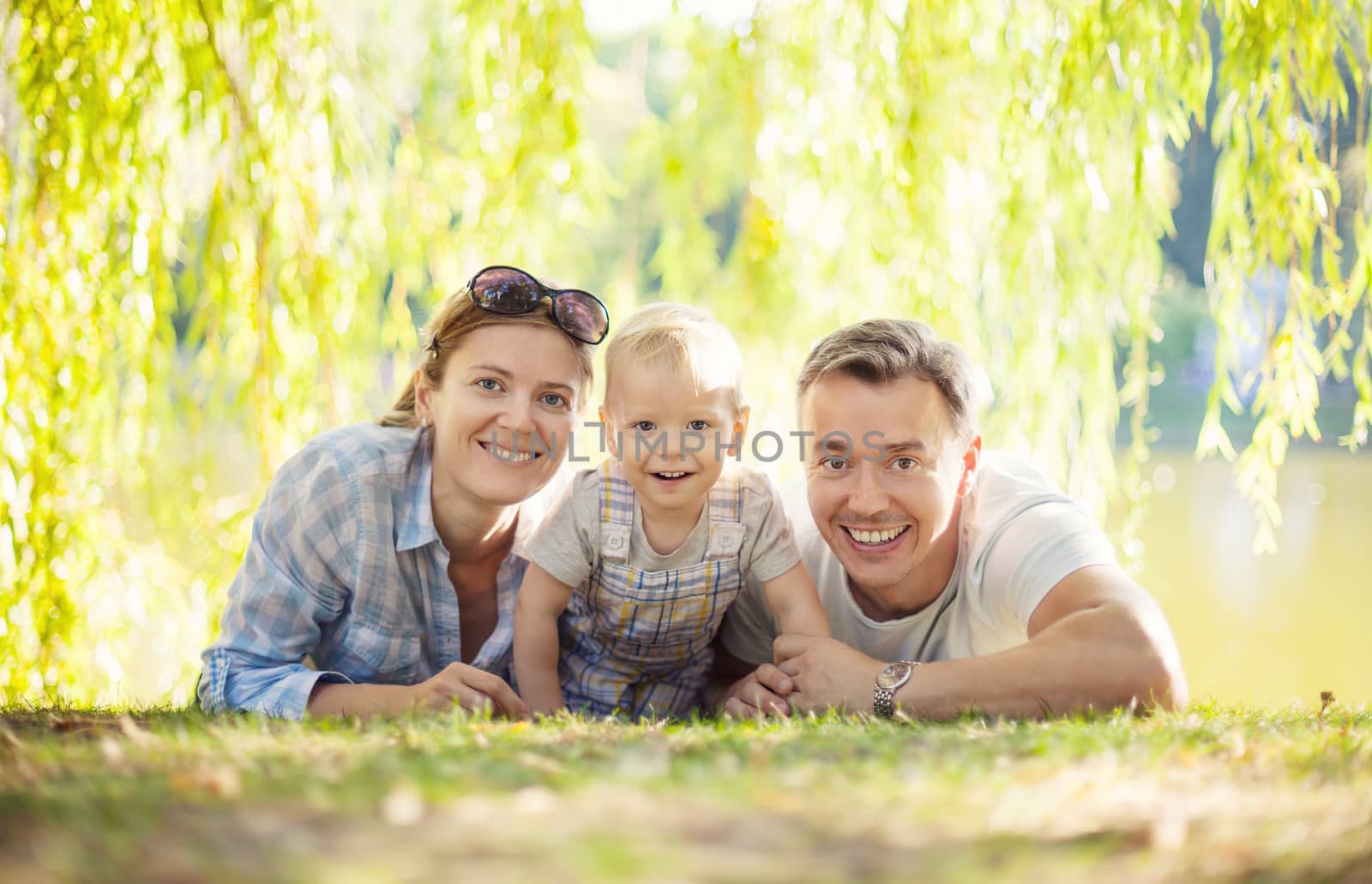Happy parents with toddler boy by photobac