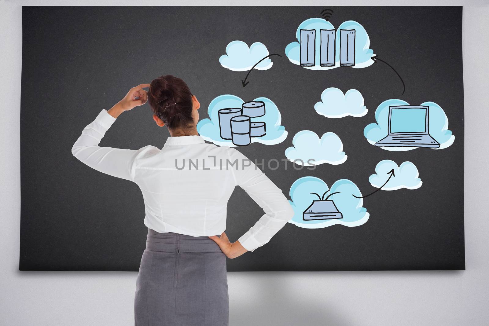 Businesswoman scratching her head against black chalkboard with business technology doodle
