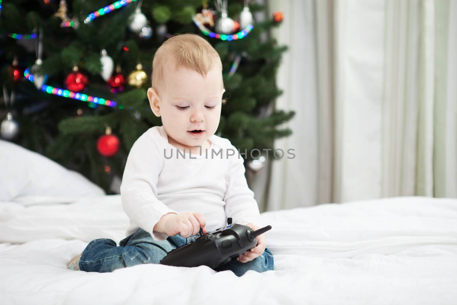 Baby boy holding RC controller at christmas time by photobac