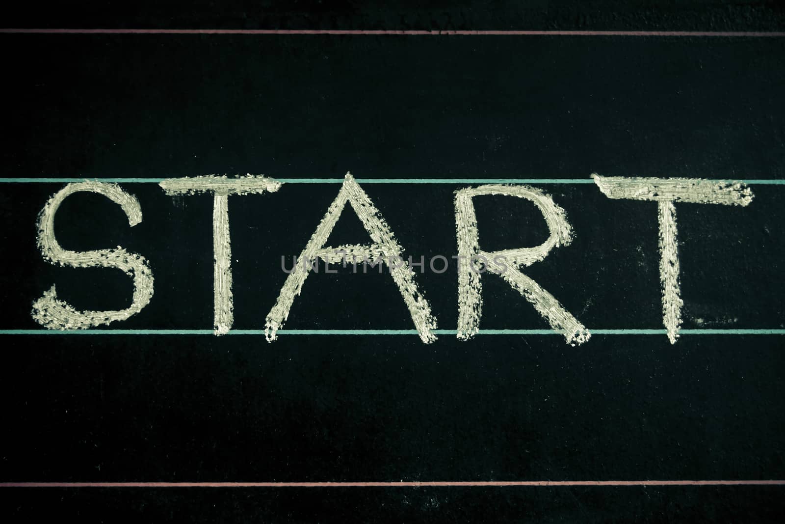 Start word handwritten on black chalkboard