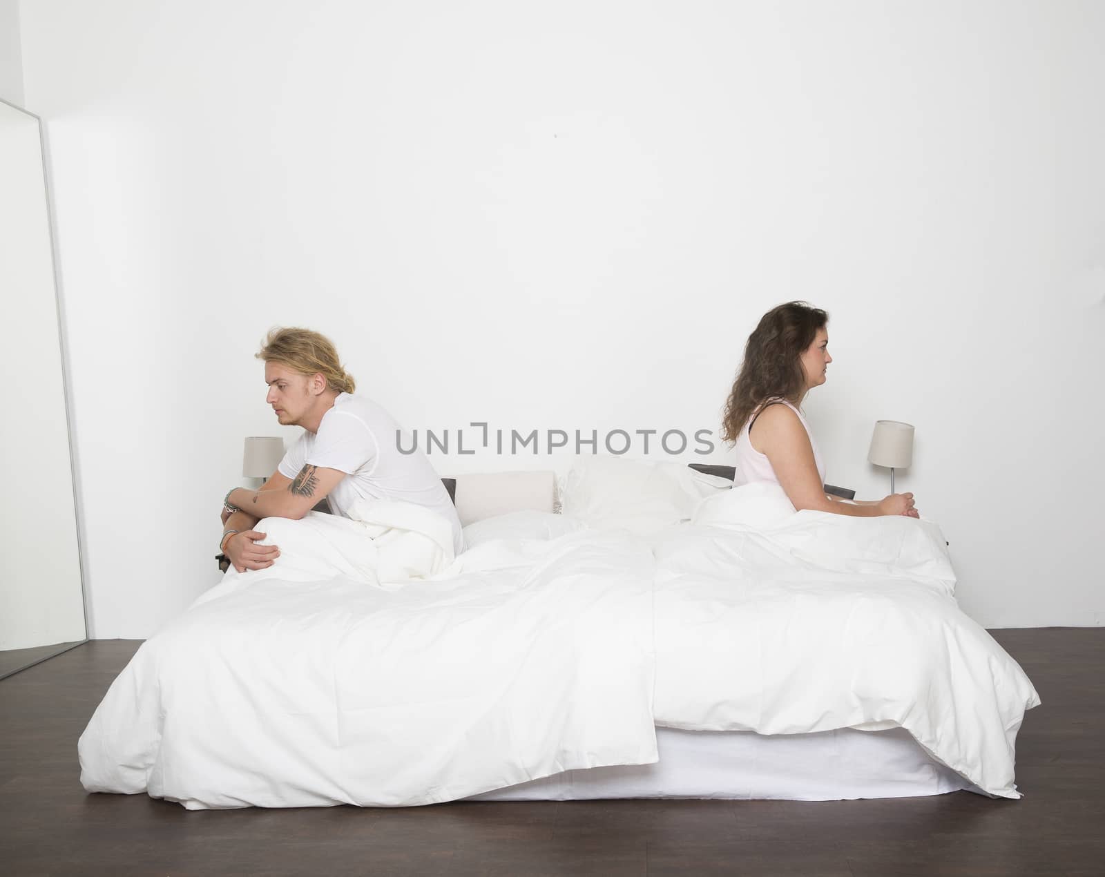 Mispleased couple in each part of the bed