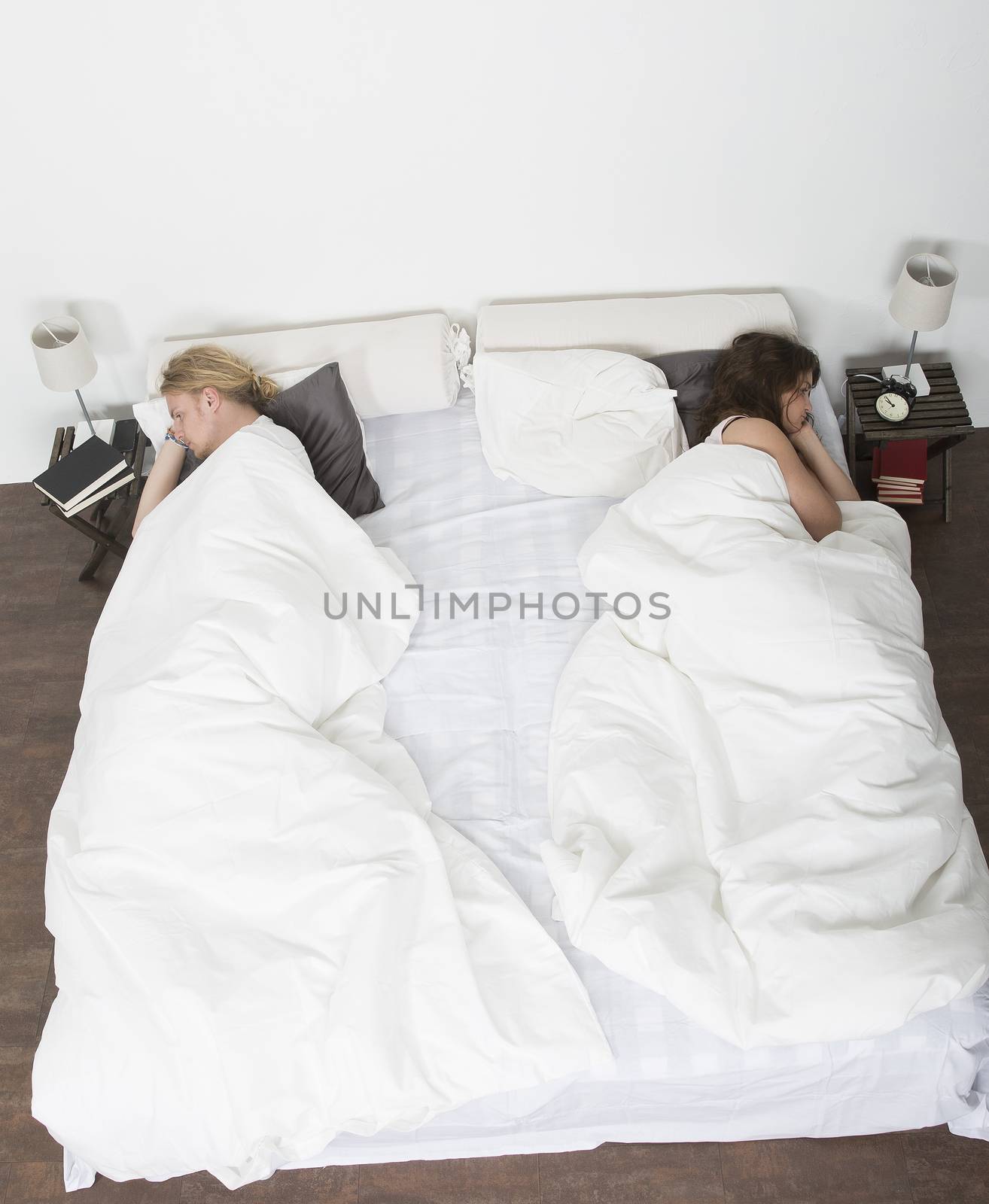 Mispleased couple in each part of the bed