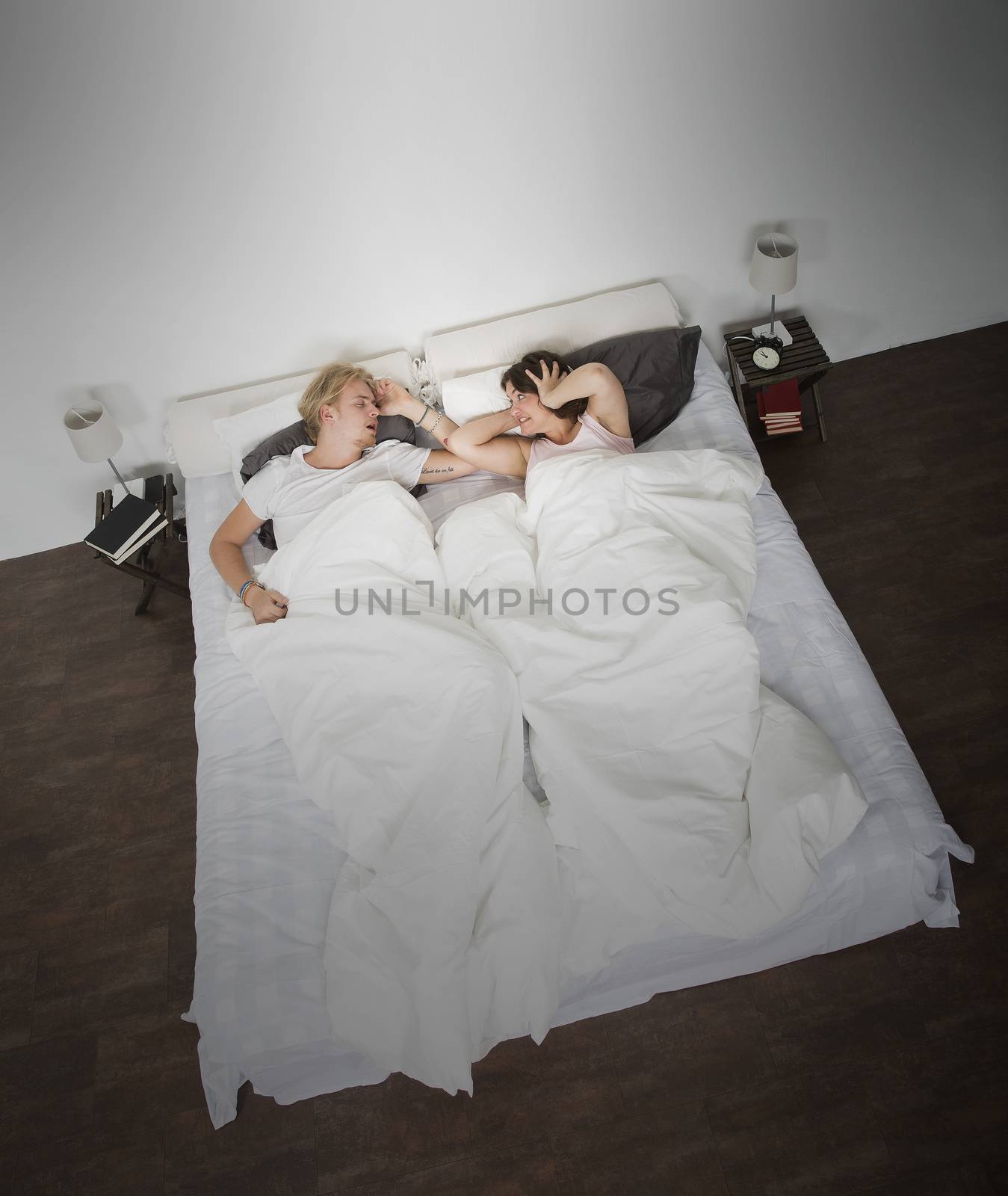 Angry wife and snoring man in the bedroom