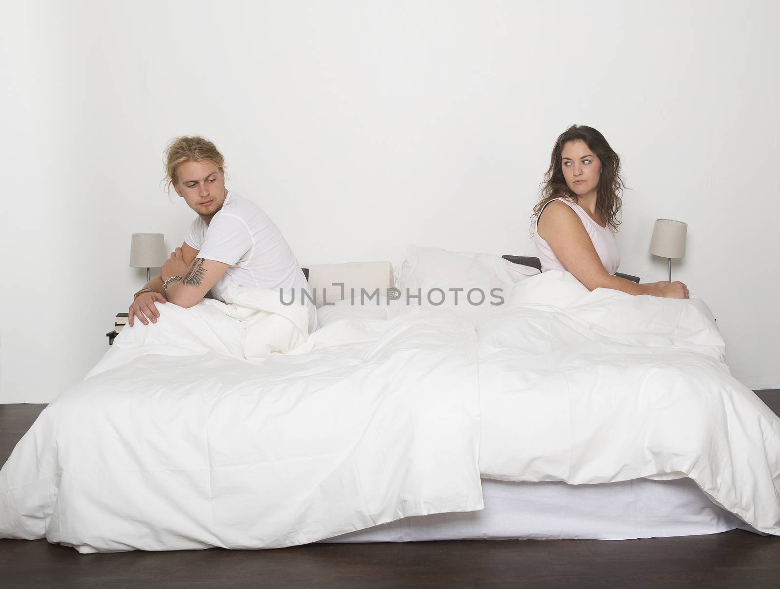Mispleased couple in each part of the bed