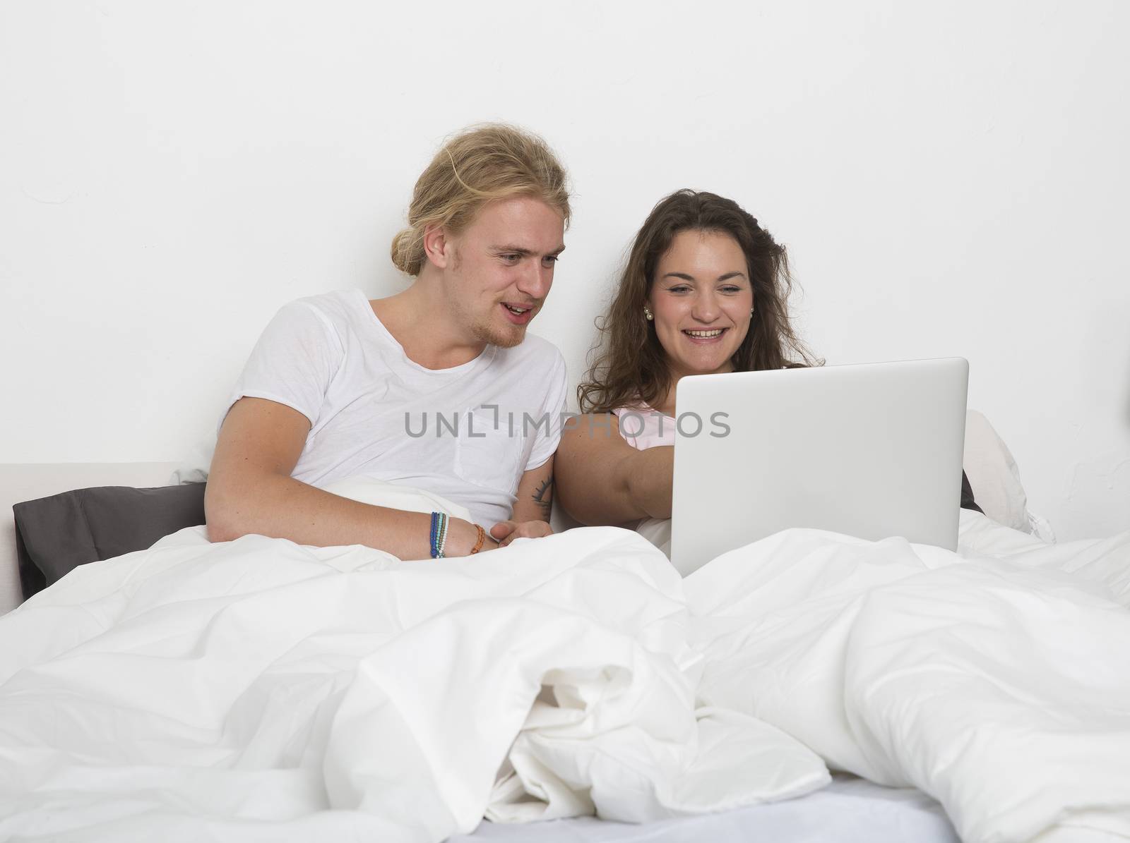 Married couple with a laptop in bed