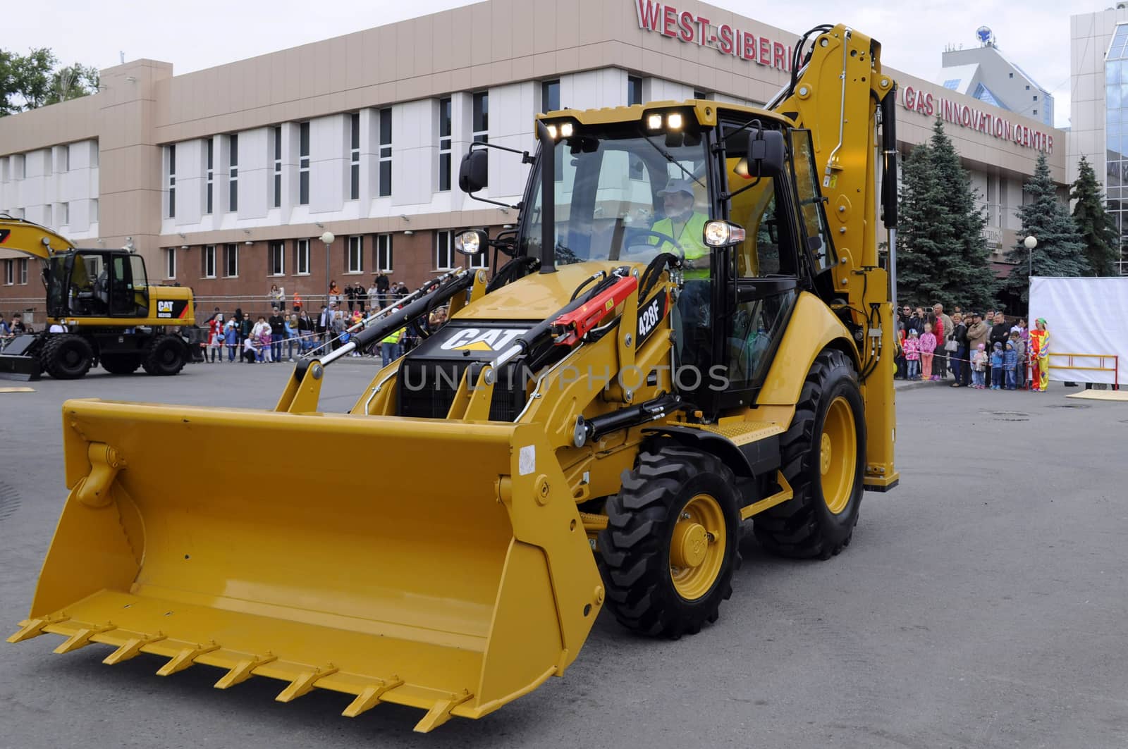 The yellow bulldozer is on the square in the city