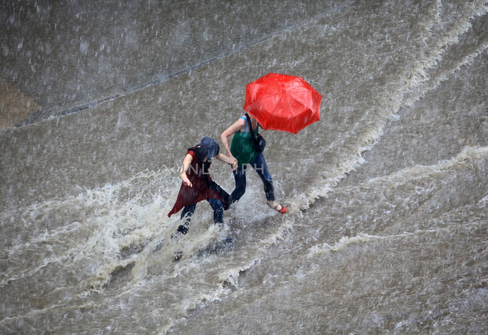 Thessaloniki, Greece - June 15, 2011: People try to cross a flooded road in the center of city. The summer months are a common phenomenon reason for the poor maintenance of drains