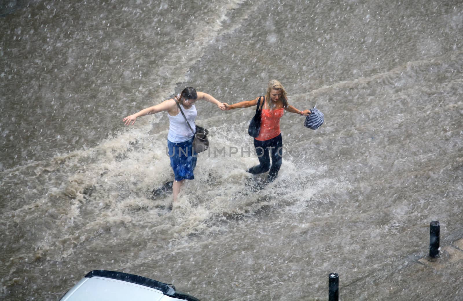 Thessaloniki, Greece - June 15, 2011: People try to cross a flooded road in the center of city. The summer months are a common phenomenon reason for the poor maintenance of drains