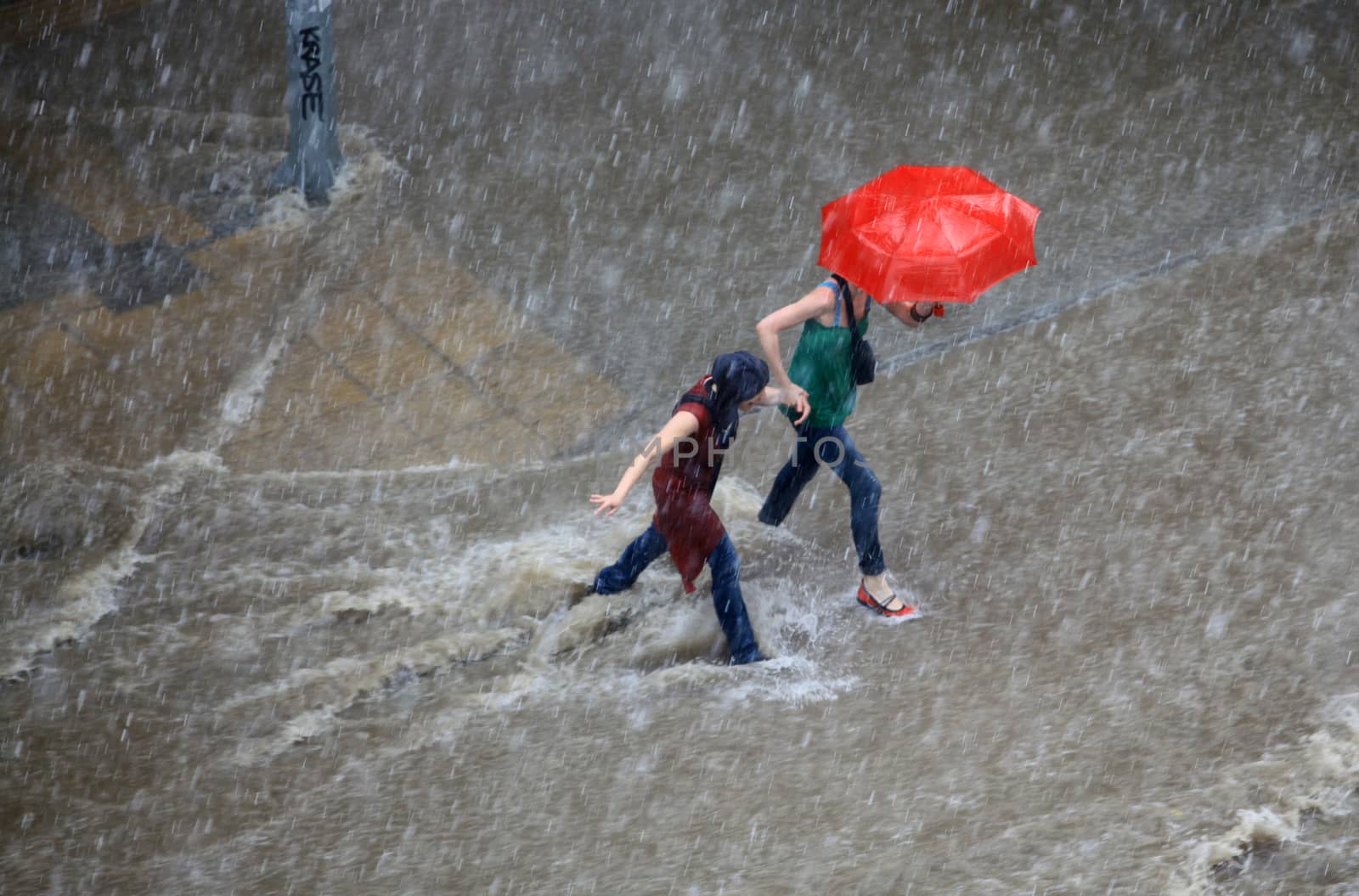 Thessaloniki, Greece - June 15, 2011: People try to cross a flooded road in the center of city. The summer months are a common phenomenon reason for the poor maintenance of drains