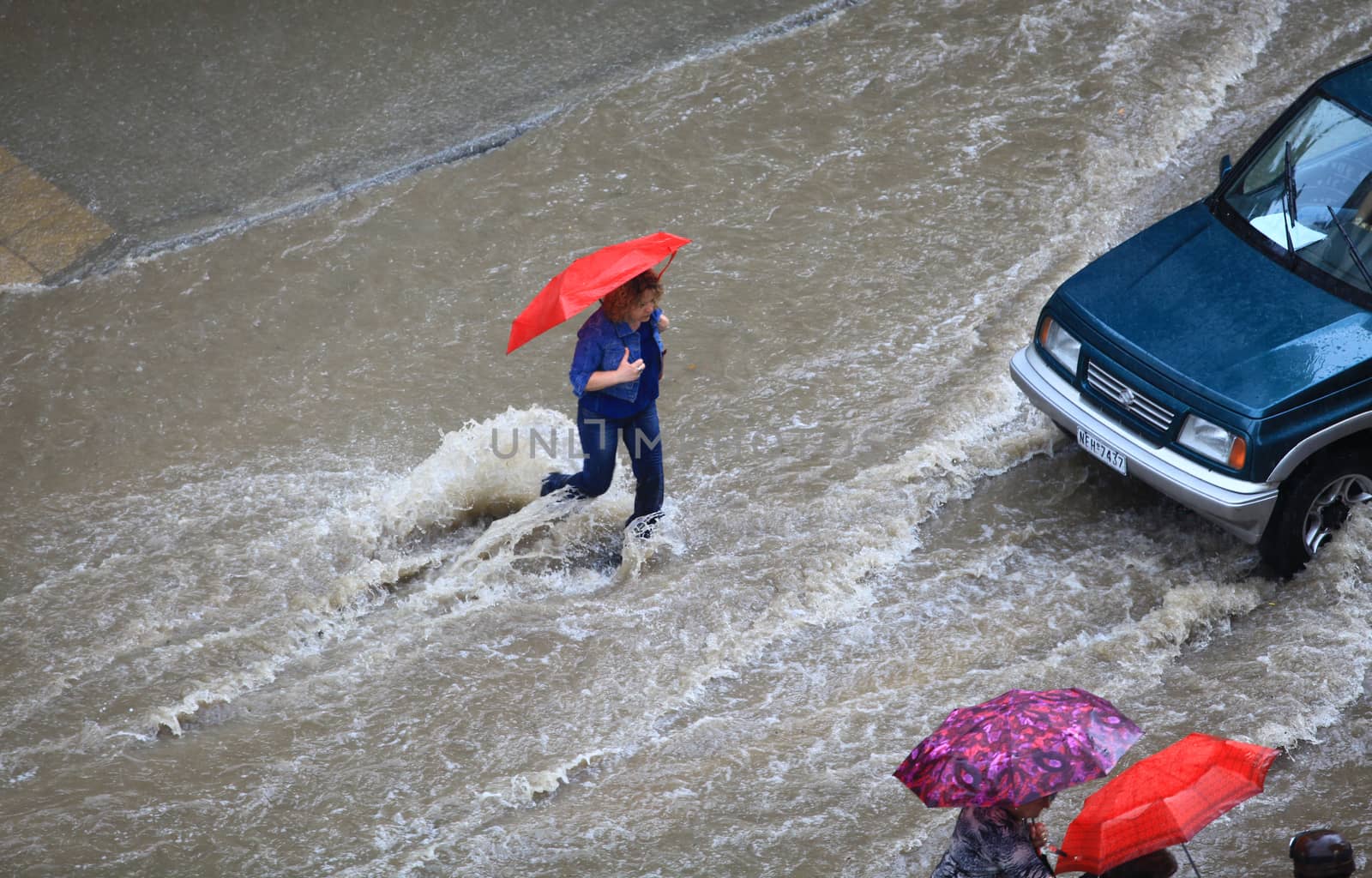 Thessaloniki, Greece - June 15, 2011: People try to cross a flooded road in the center of city. The summer months are a common phenomenon reason for the poor maintenance of drains