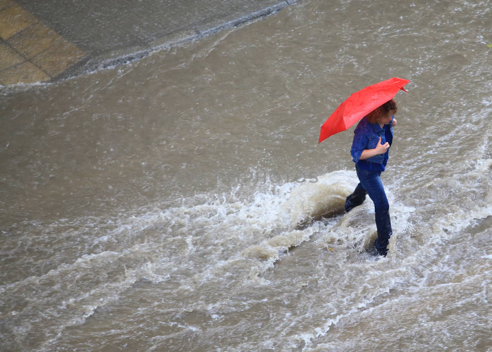 People try to cross a flooded road by Portokalis