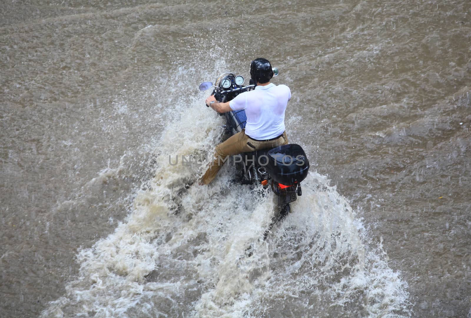 People try to cross a flooded road by Portokalis