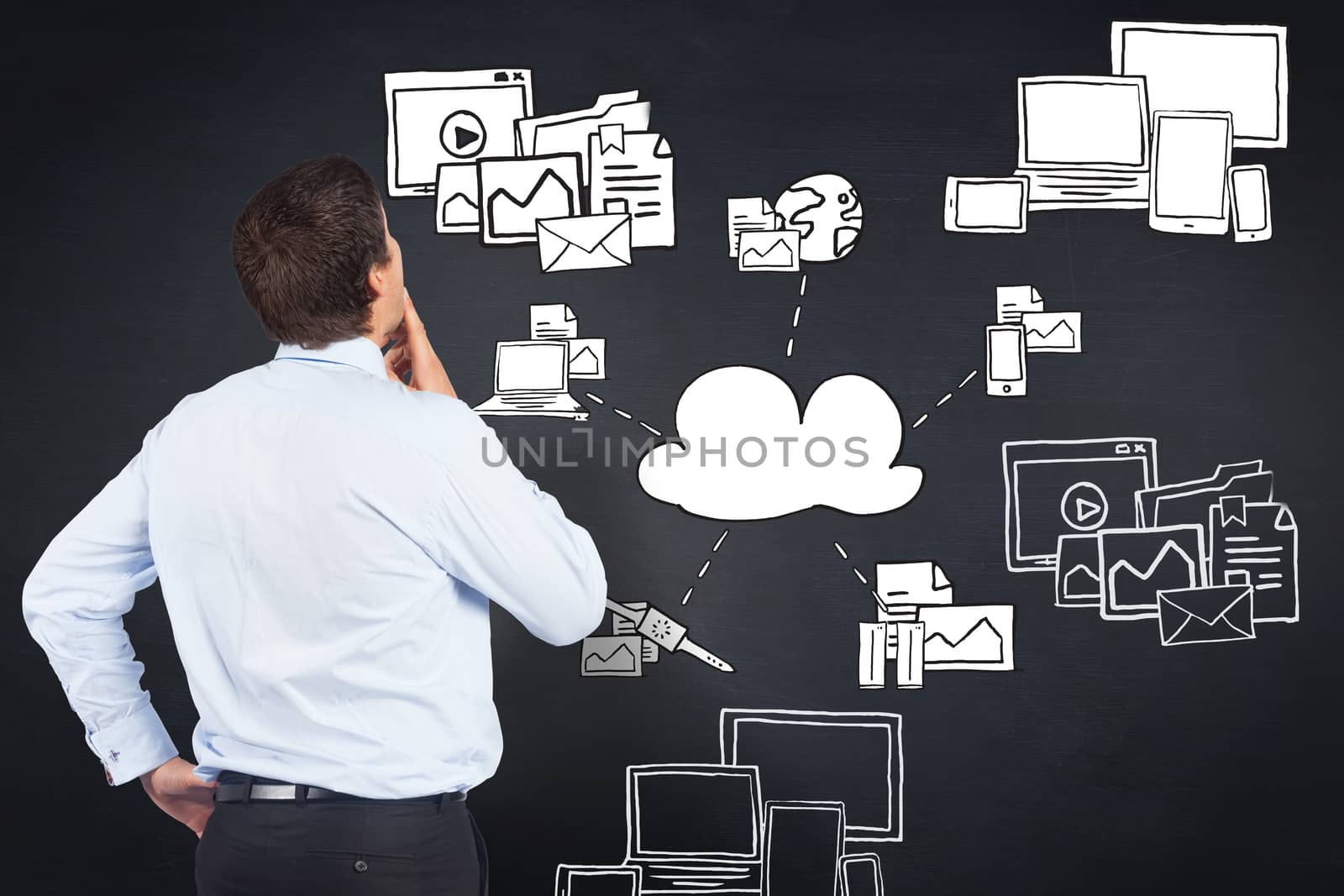 Thinking businessman touching his chin against blackboard with technology doodles