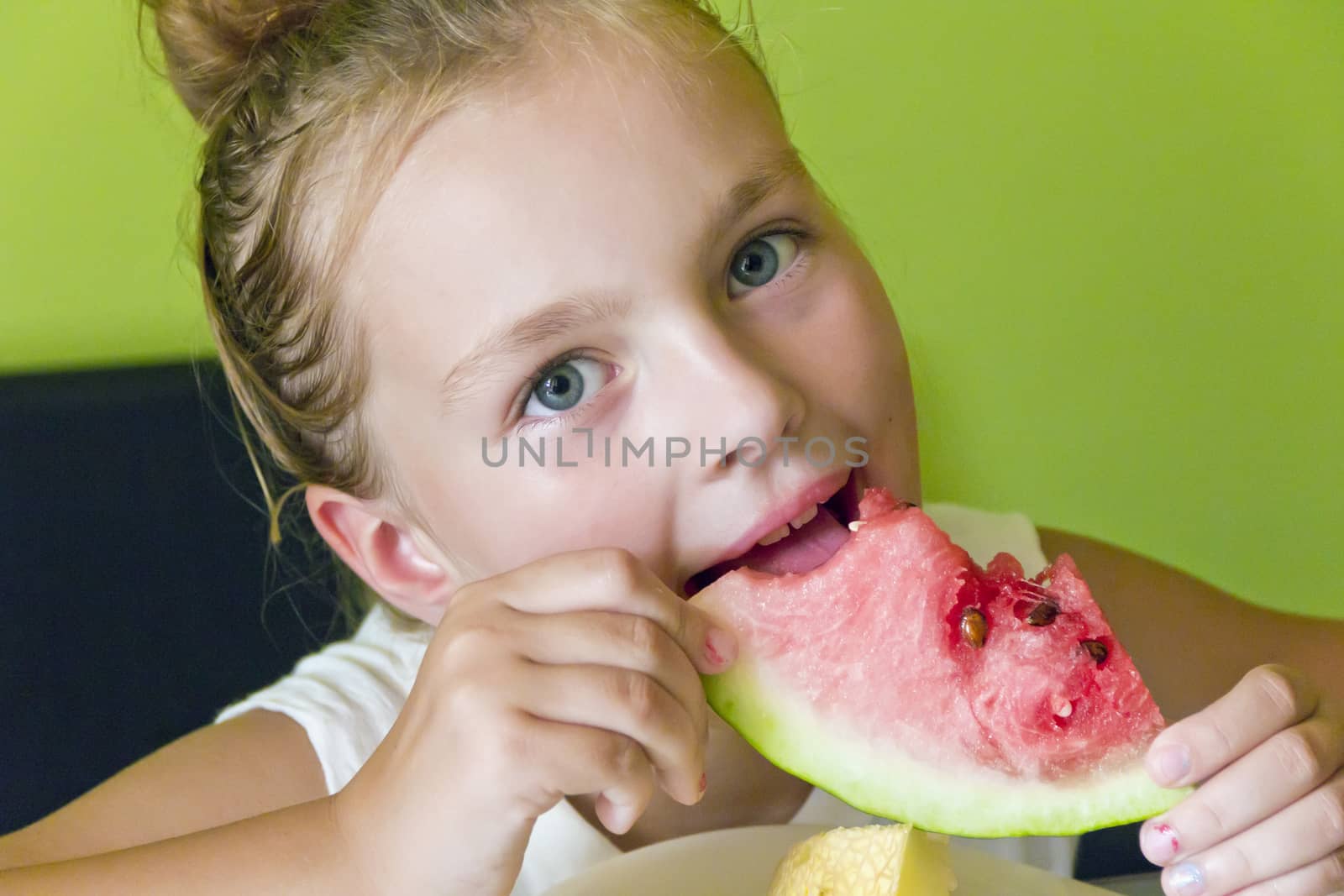Photo of the cute girl eating watermelon