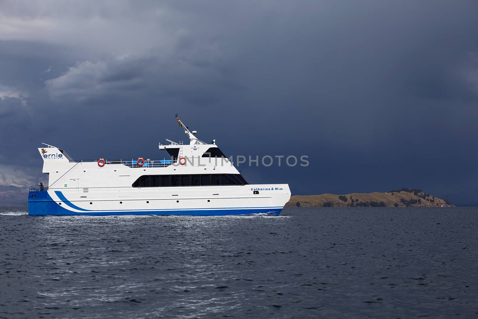LAKE TITICACA, BOLIVIA - NOVEMBER 5, 2014: Big passenger ferry on Lake Titicaca close to the shore of the popular travel destination of Isla del Sol (Island of the Sun) on November 5, 2014 on Lake Titicaca, Bolivia. In the back is visible with thunderclouds above it. 