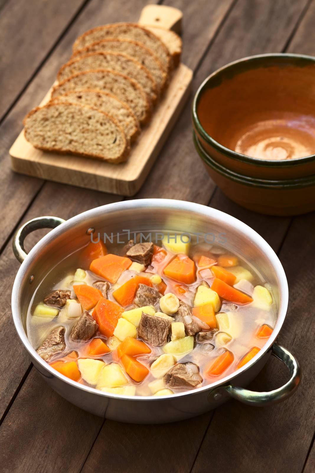 Pot filled with traditional Hungarian soup called Gulyasleves made of beef, potato, carrot, onion, csipetke (homemade pasta) and seasoned with salt and paprika (Selective Focus, Focus one third into the soup)