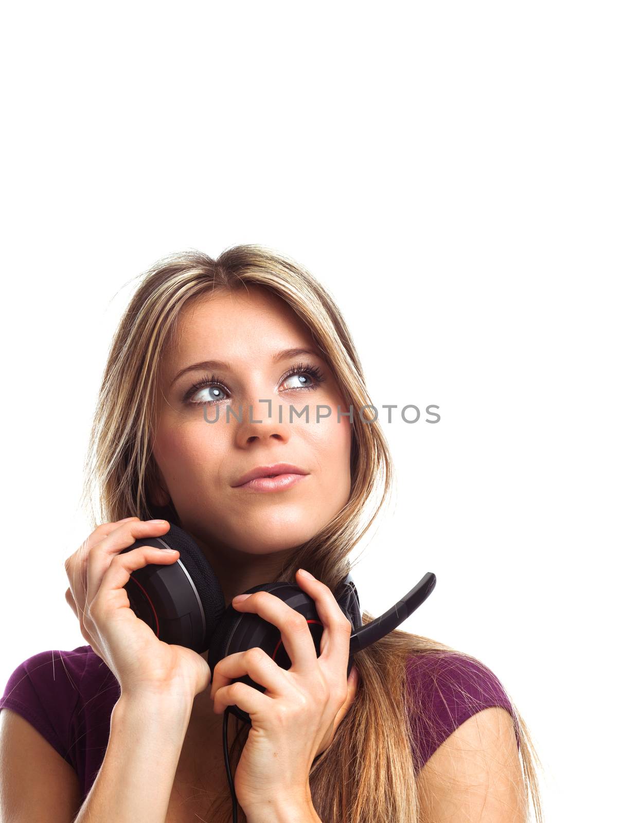 Pretty young woman with earphones looking up, on white