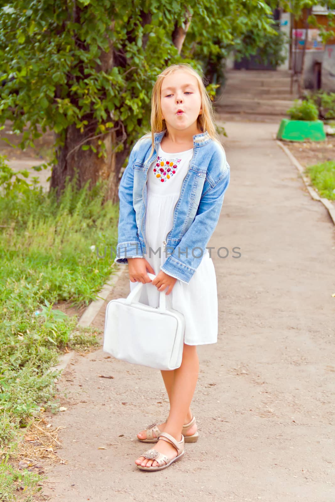 Cute girl playing with white bag in summer