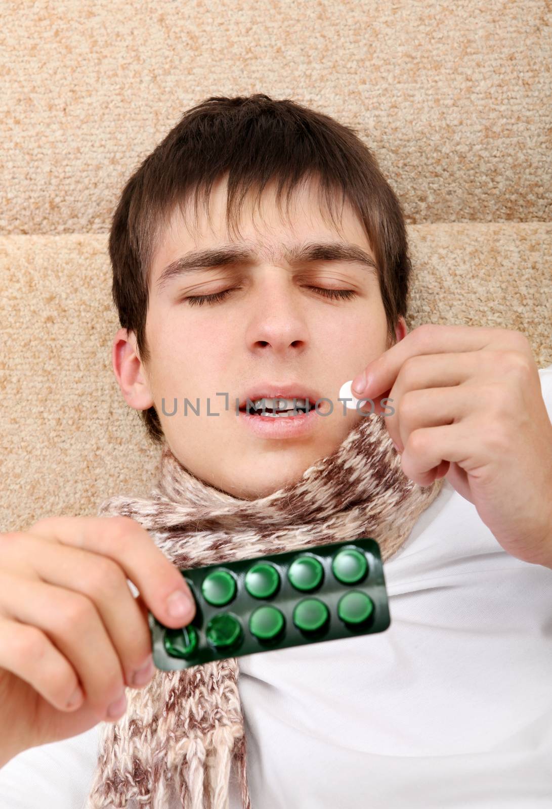 Sick Teenager taking a Pill on the Bed at the Home