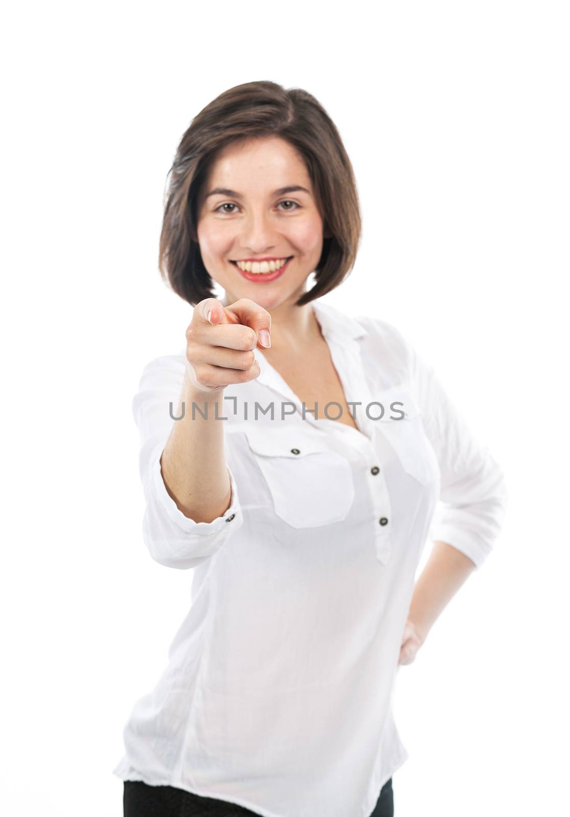 Portrait of a beautiful young woman pointing in front of her. Focus on her face, isolated on white