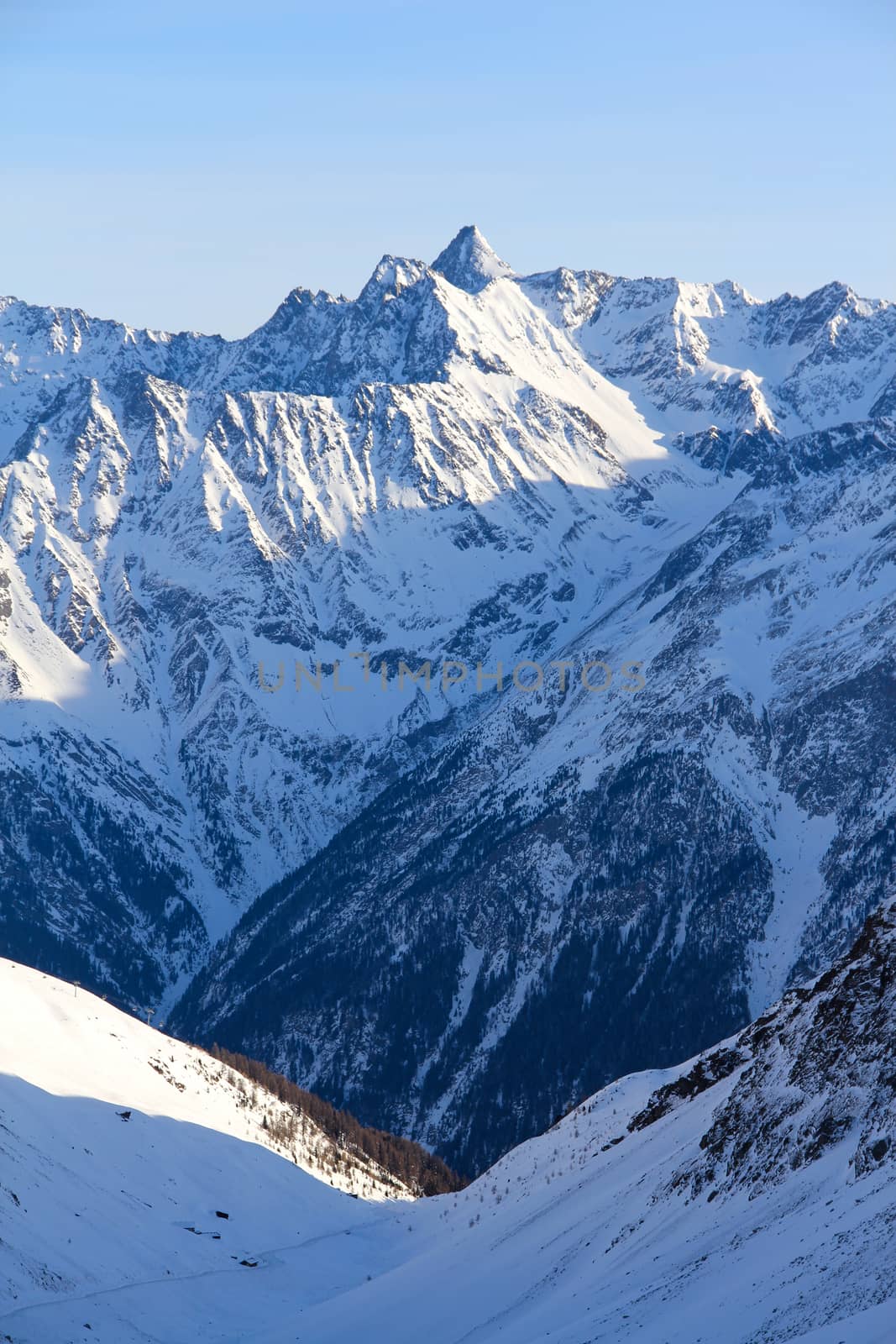 Tops of winter alp mountains at sunny day