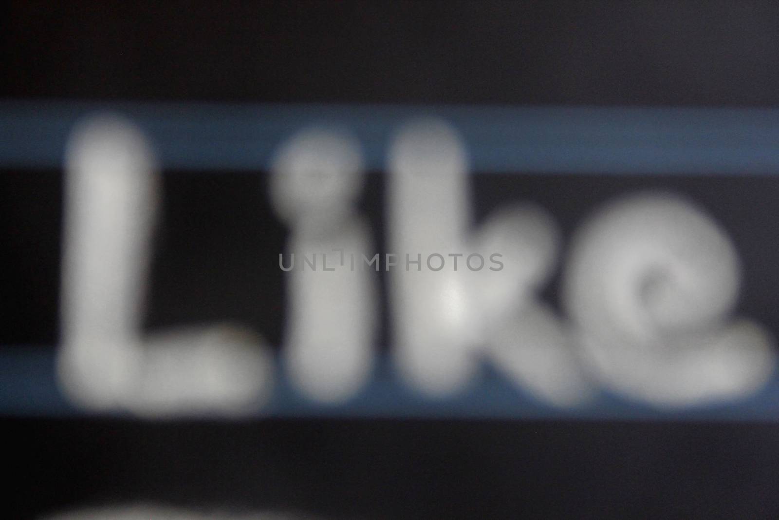 blur image of like word handwritten on black chalkboard