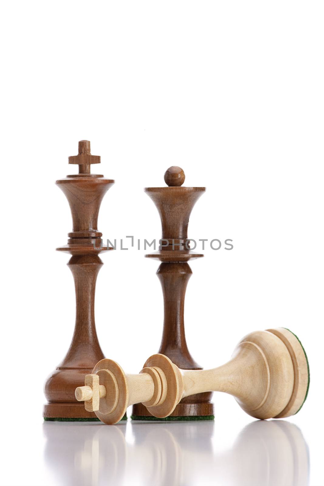 chess - black king and queen standing over defeated white king