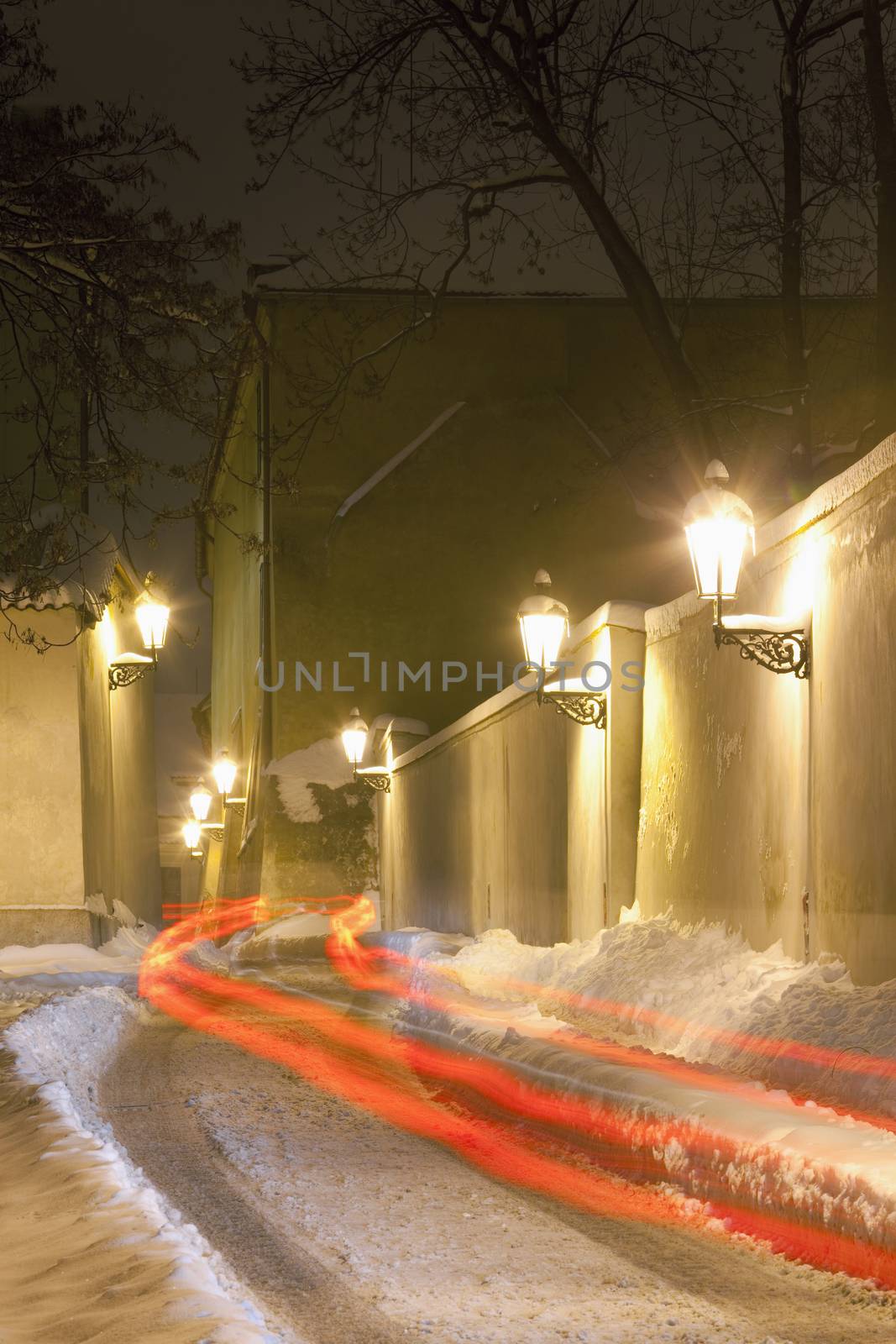 prague - narrow street at hradcany with gas lanterns in winter