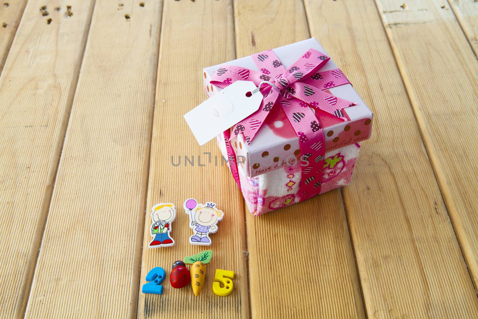 Pink Christmas gift box full of xmas  on wood background.