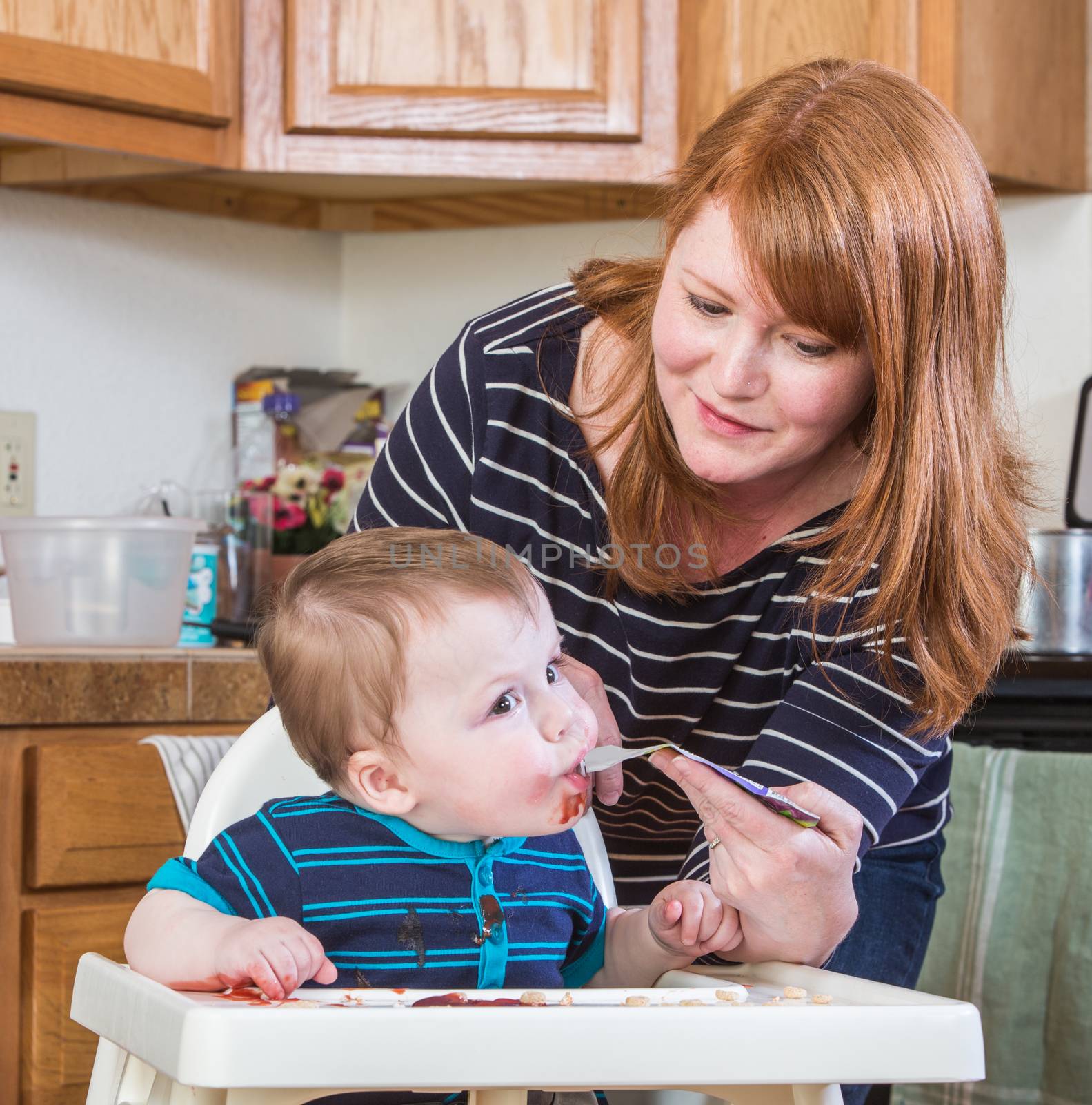 A woman feeds her baby juice in the kitchen