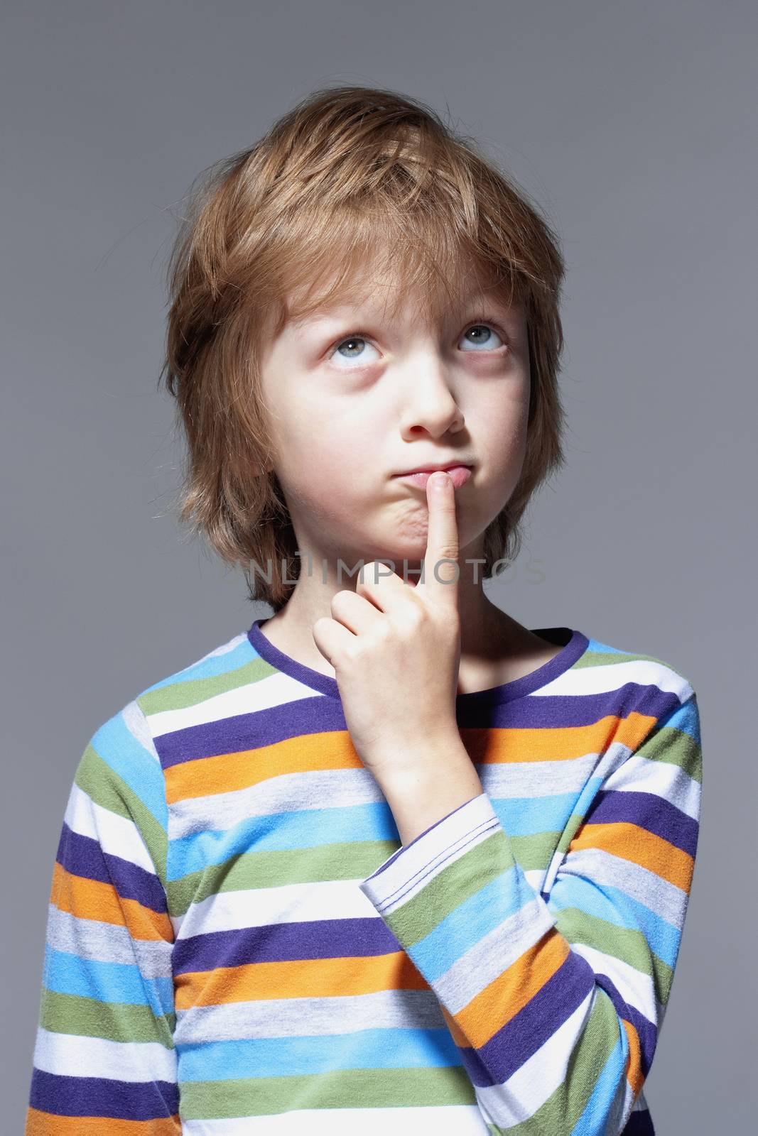 Boy Looking Thinking, Finger on his Mouth - Isolated on Gray