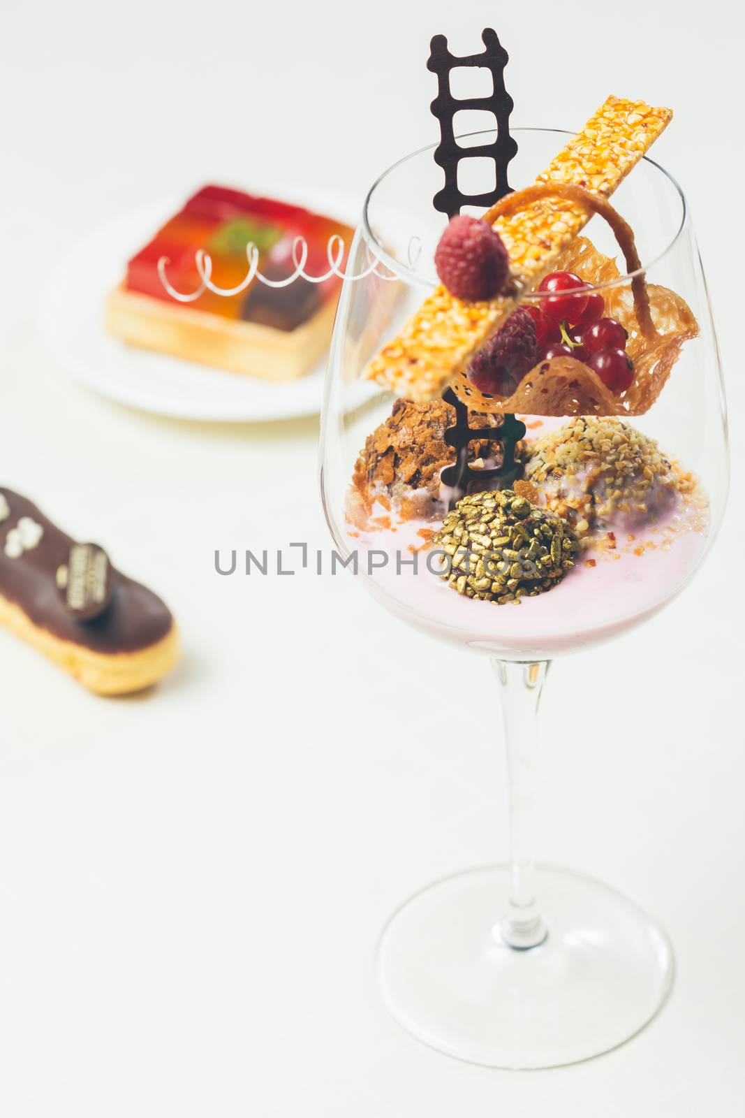 Close up of chocolate truffles with raspberry yogurt in elegant glasses. Warm colors. Shallow dof. 