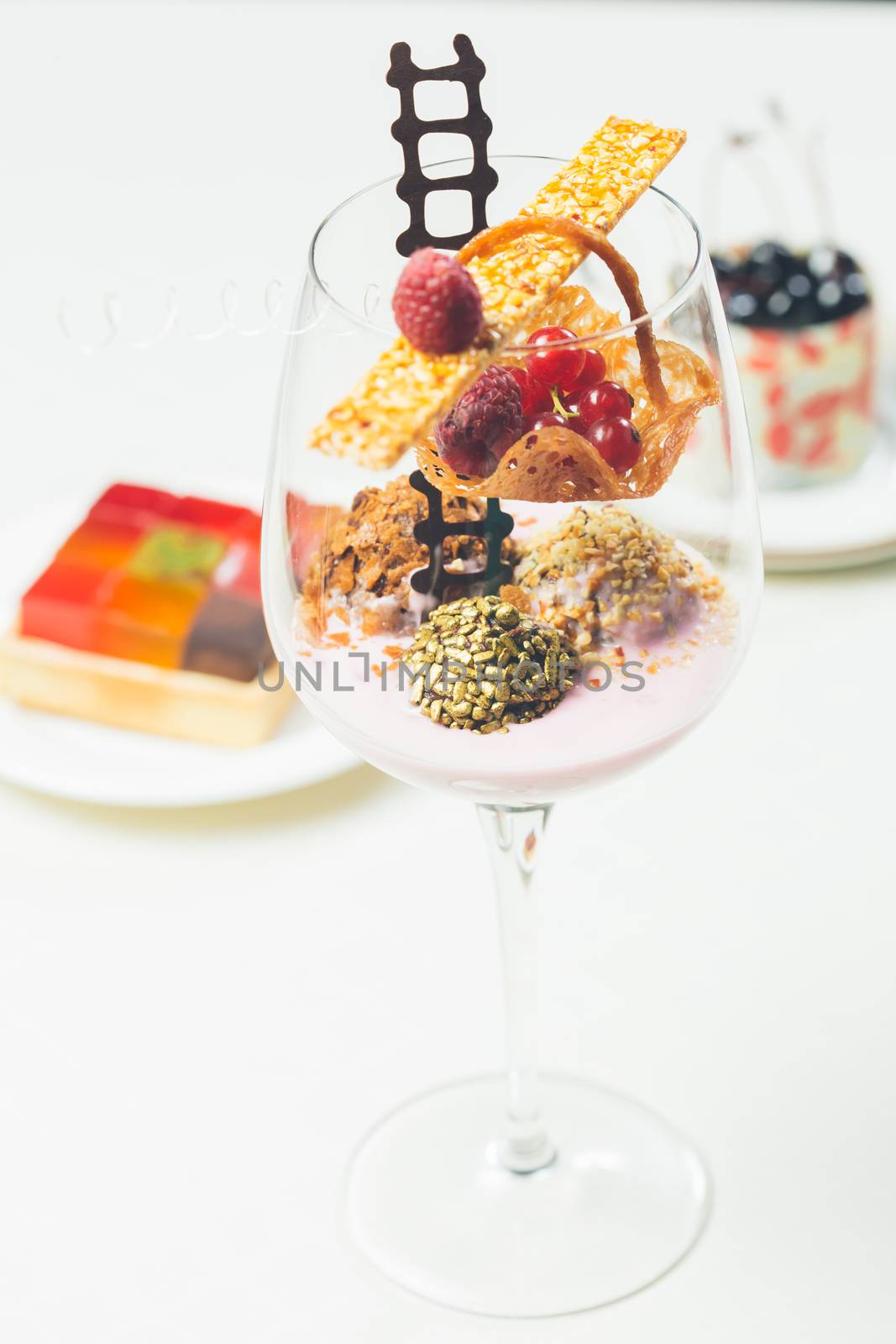 Close up of chocolate truffles with raspberry yogurt in elegant glasses. Warm colors. Shallow dof. 