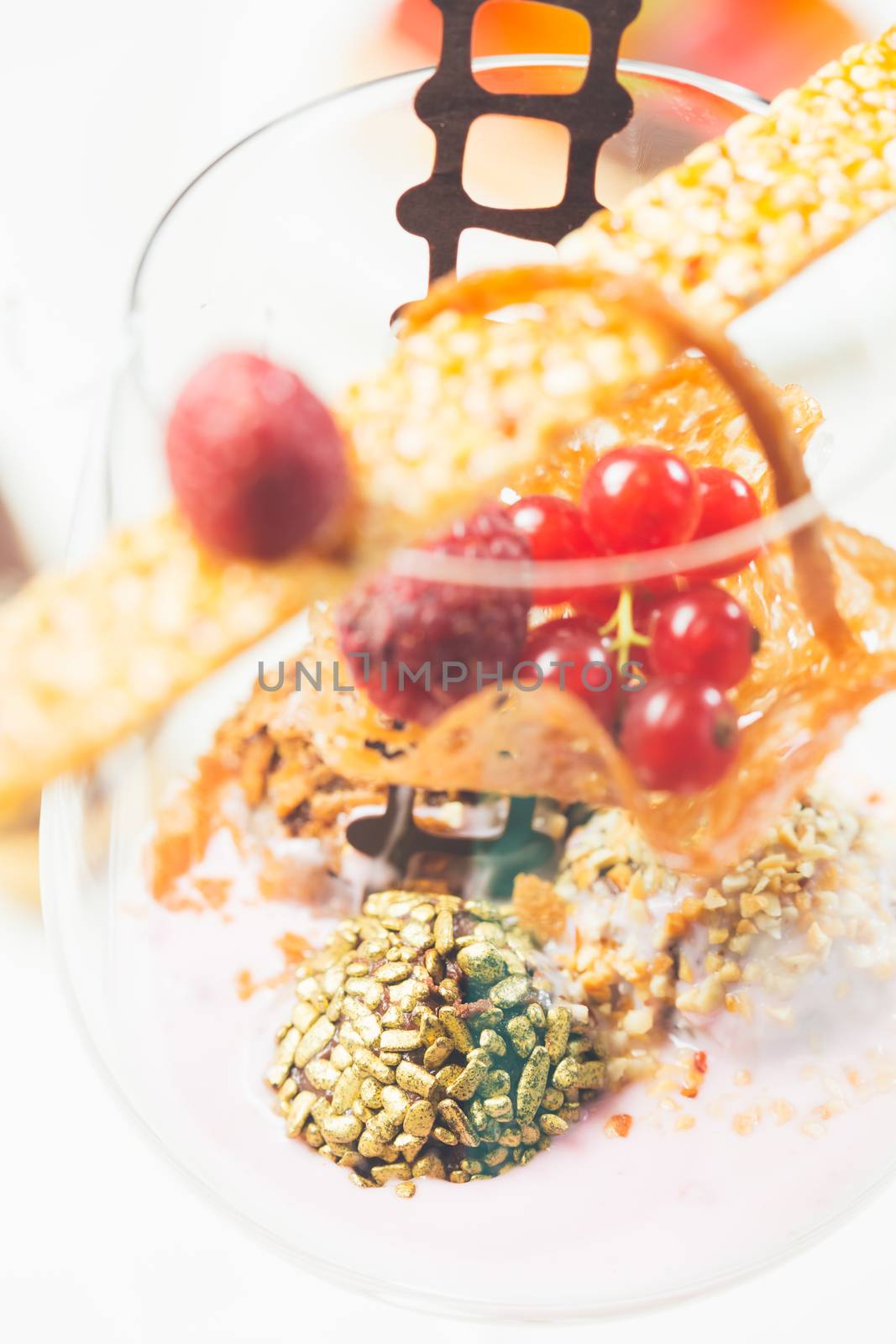 Close up of chocolate truffles with raspberry yogurt in elegant glasses. Warm colors. Shallow dof. 