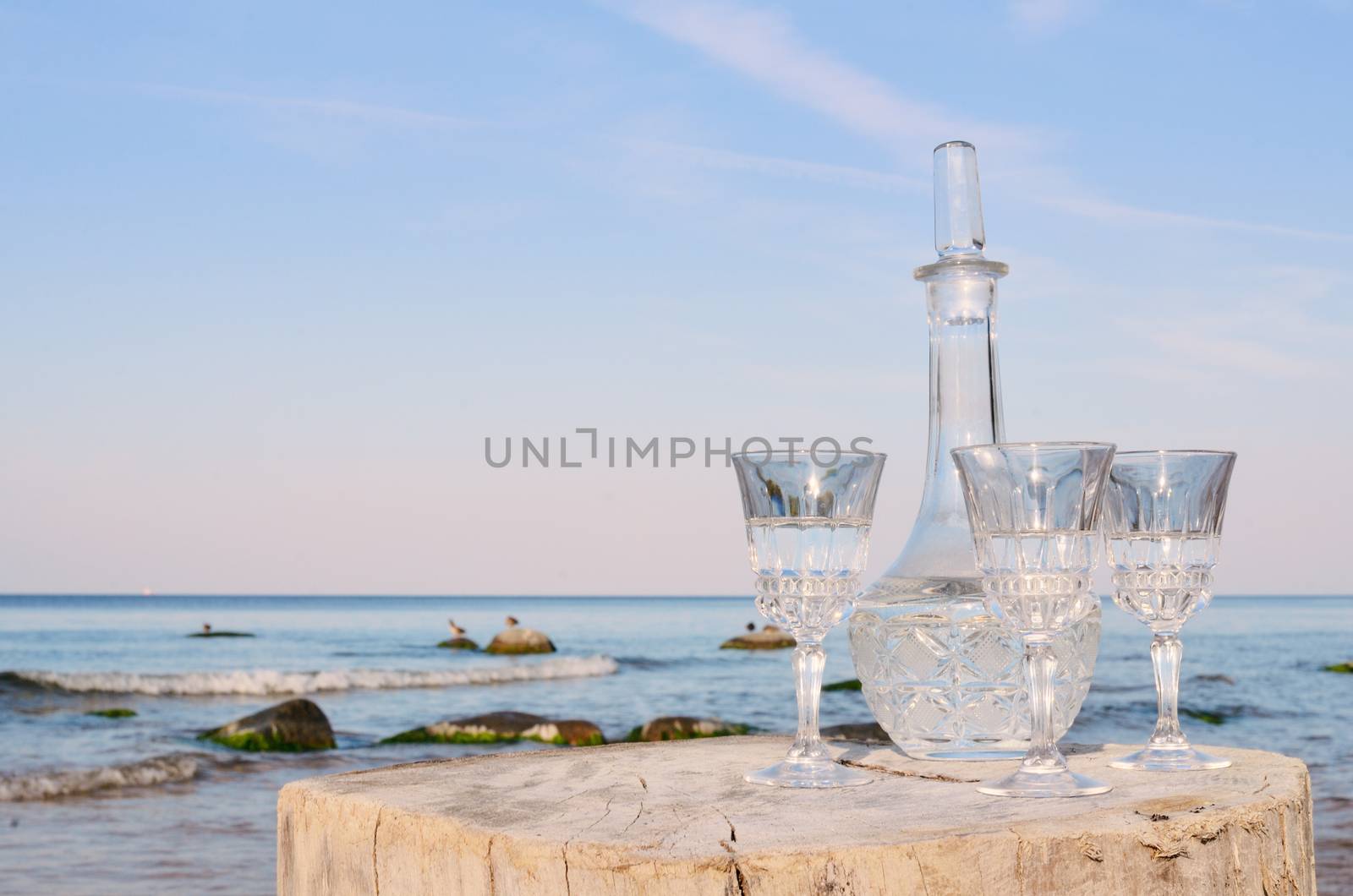 Crystal glasses and decanter on the beach