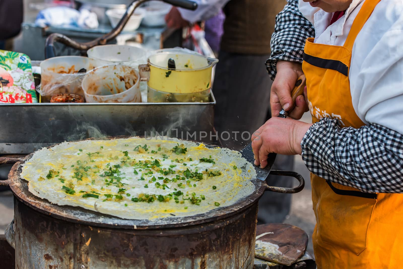 Shanghai, China - April 7, 2013: woman cooking traditional chinese street food cuisine at the city of Shanghai in China on april 7th, 2013