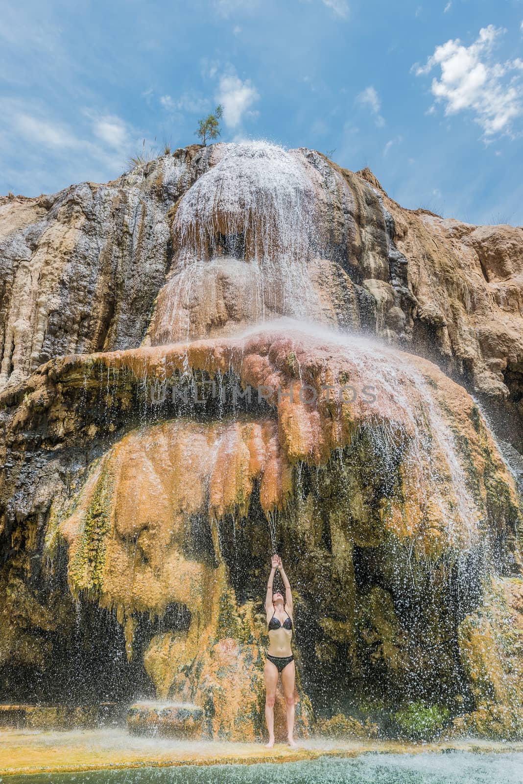one woman bathing ma'in hot springs waterfall Jordan by PIXSTILL