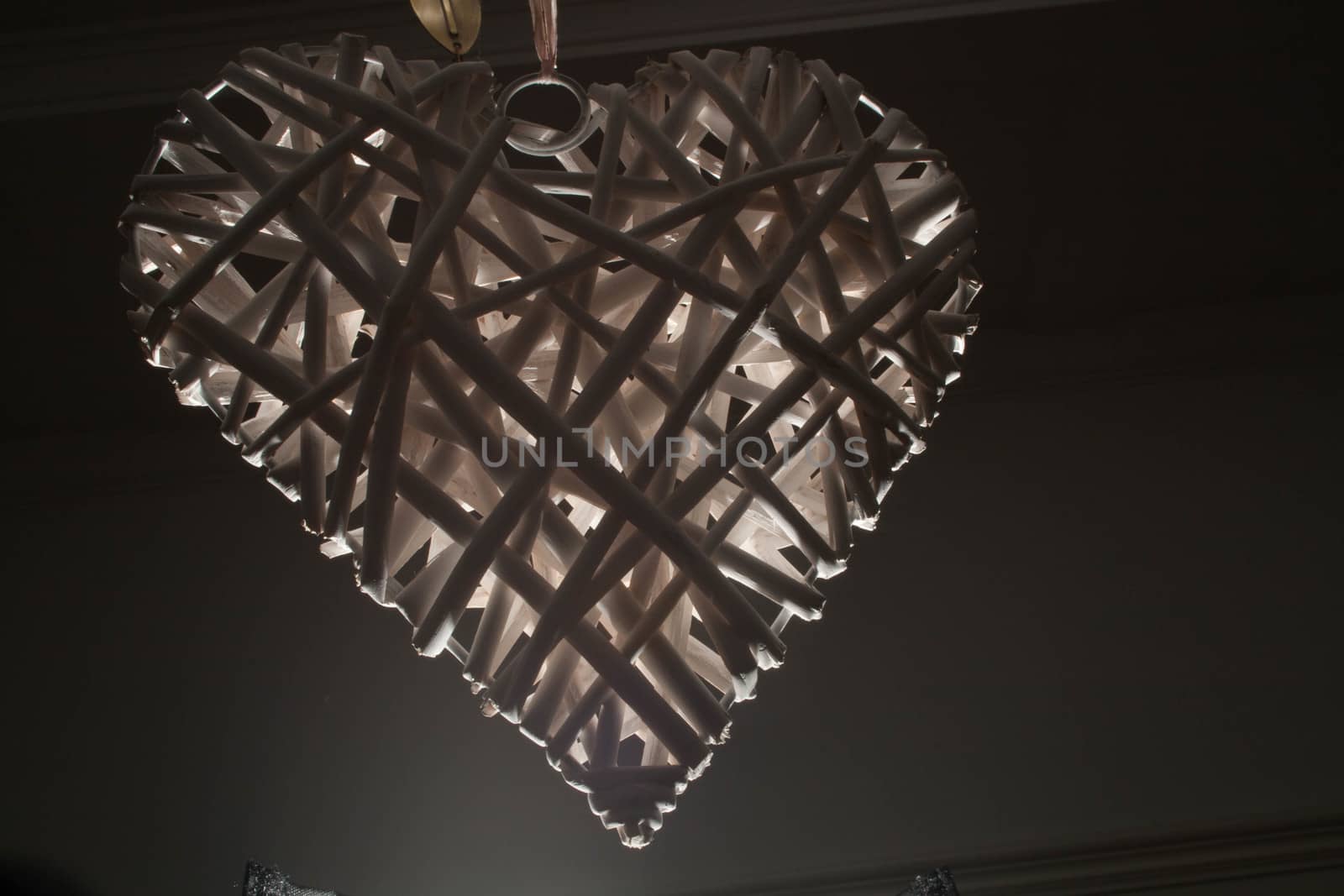 A low key close up of a white wicker heart.