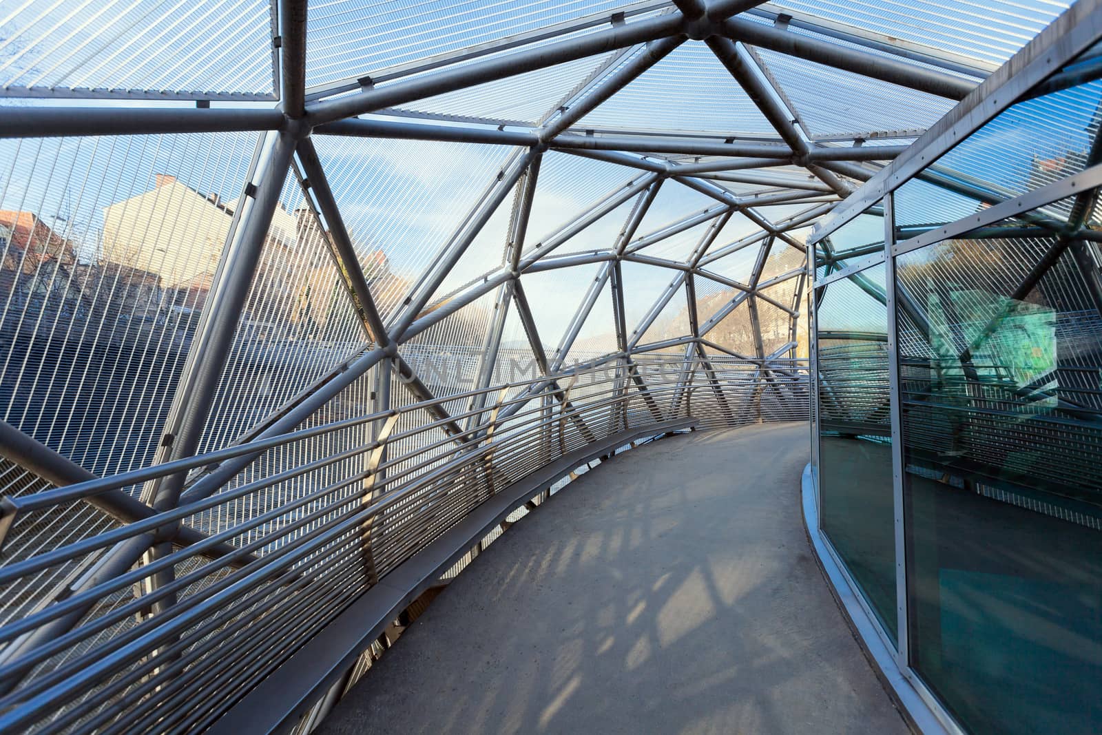 Graz, Austria - January 16, 2011: Island on Mur river connected by a modern steel and glass bridge, Styria, Graz, Austria