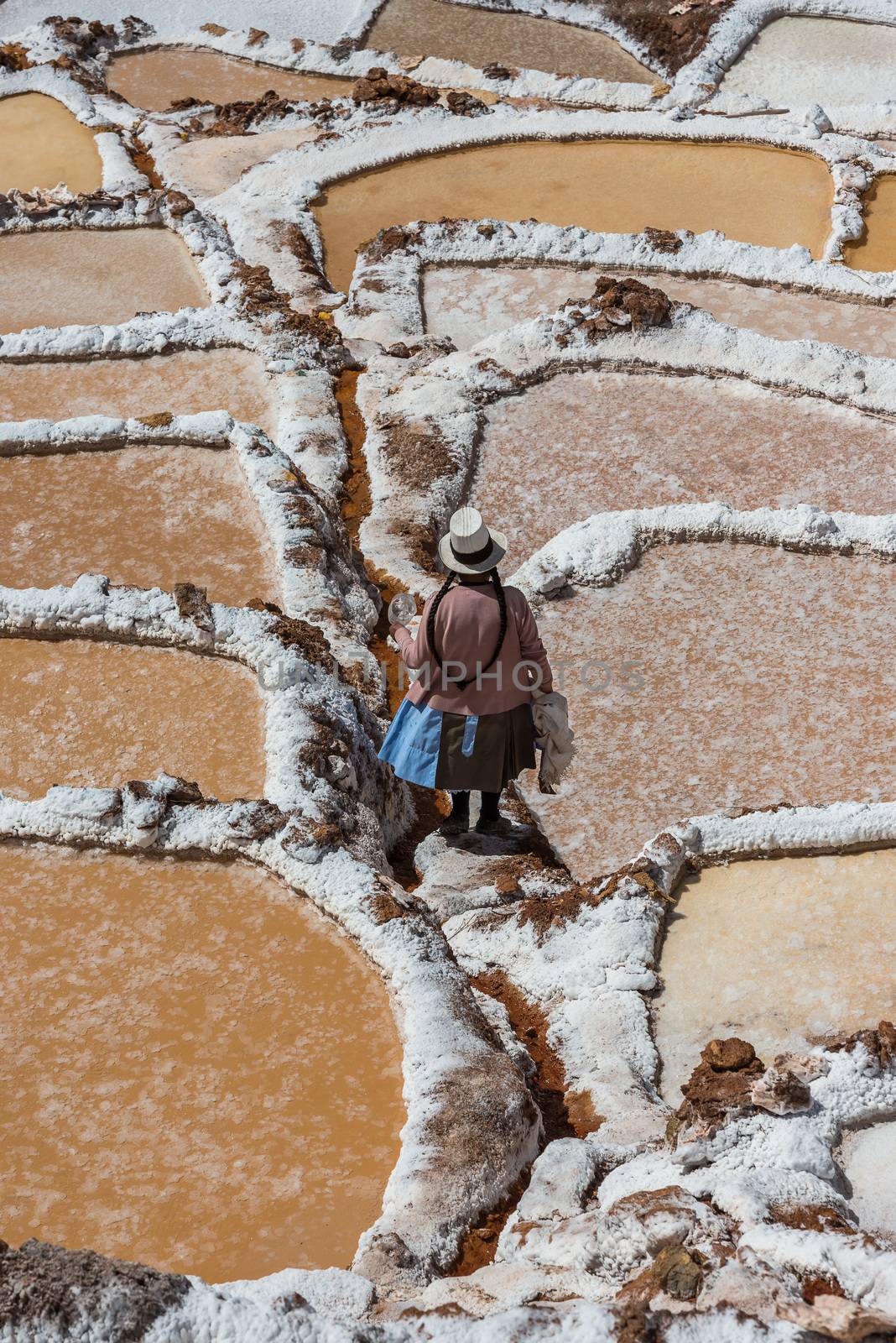 Maras, Peru - July 23, 2013: woman at Maras salt mines in the peruvian Andes at Cuzco Peru on july 23, 2013