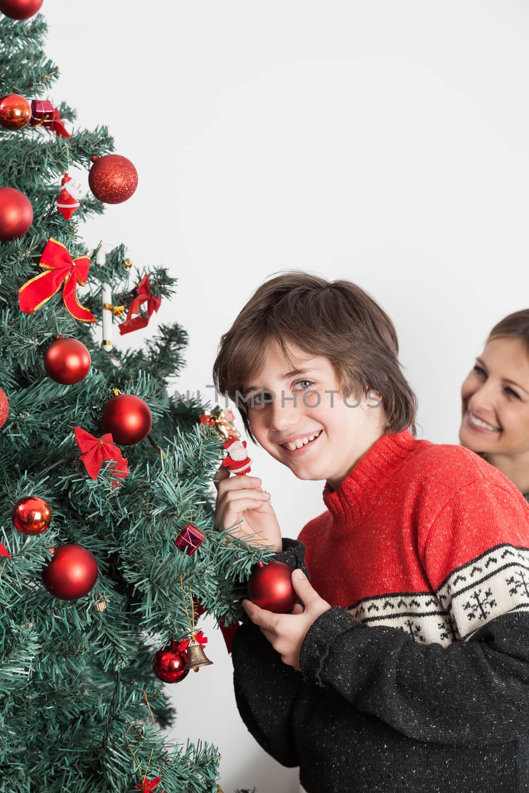 10-12, anticipation, backroud, ball, balls, boy, camera, casual, caucasian, christmas, christmastime, decorating, decorations, eyes, glass, green, holding, holiday, home, indoors, juice, look, looking, male, model, old, people, property, red, releases, situation, teenager, tree, vertical, white, years