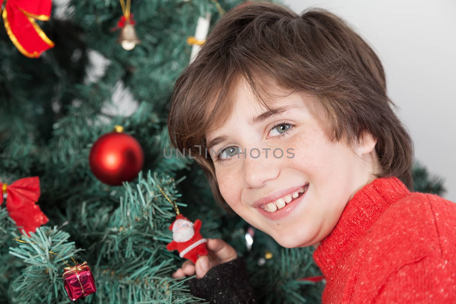 Happy boy beside the christmas tree by ifilms