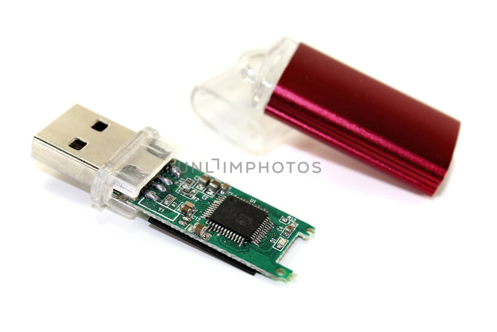 disassembled red USB flash drive on a light background