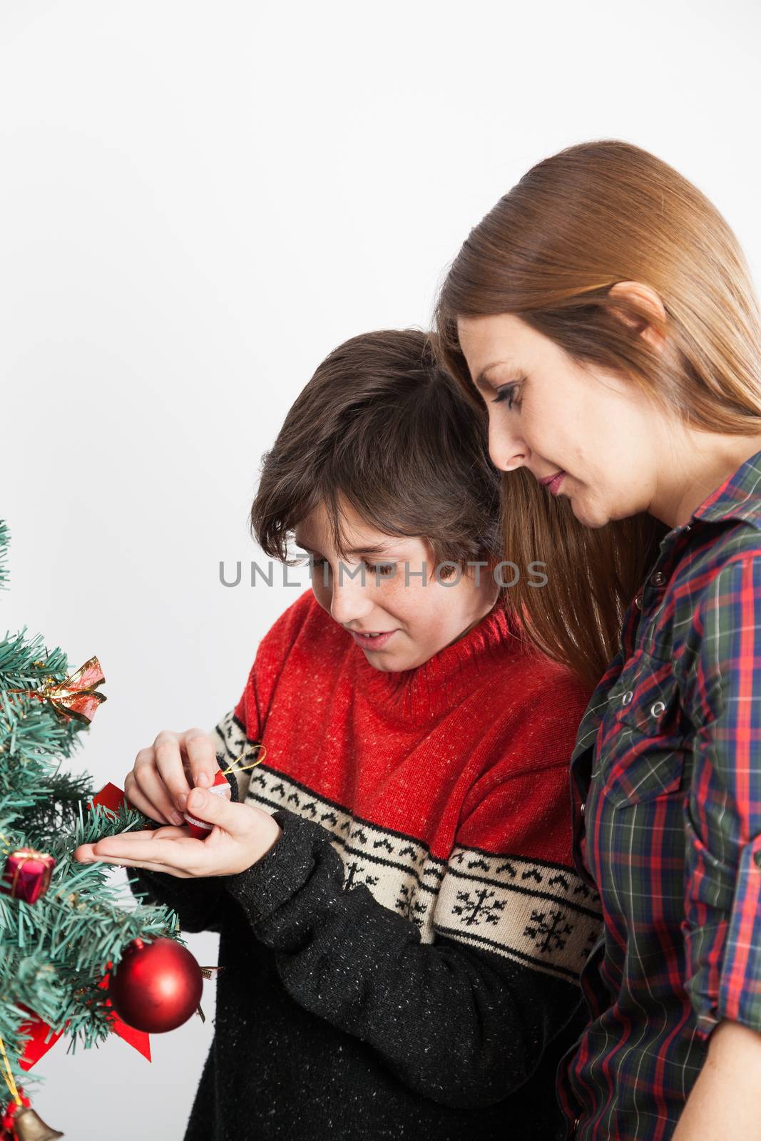 Boy with his mom decorating the christmas tree by ifilms